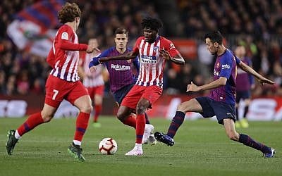 Atletico forward Antoine Griezmann, left, Atletico midfielder Thomas Partey, and Barcelona's Sergio Busquets, right, vie for the ball during a Spanish La Liga soccer match between FC Barcelona and Atletico Madrid at the Camp Nou stadium in Barcelona, Spain, Saturday April 6, 2019. (AP Photo/Manu Fernandez)