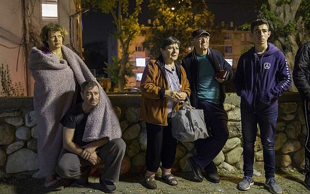 Israelis stand outside their building after it was hit by a rocket fired from Gaza in the costal city of Ashkelon, Israel, Sunday, May 5, 2019. (AP Photo/Tsafrir Abayov) Israelis stand outside their building after it was hit by a rocket fired from Gaza in the costal city of Ashkelon, Israel, Sunday, May 5, 2019. (AP Photo/Tsafrir Abayov)