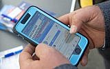 A man reads an AfD website on his mobile phone in Gera, Germany, Friday, May 17, 2019 (AP Photo/Jens Meyer)