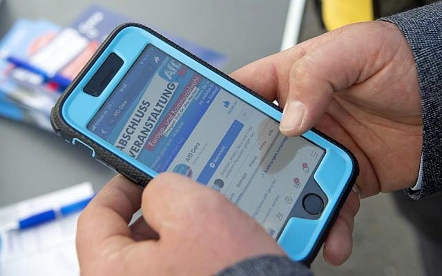 A man reads an AfD website on his mobile phone in Gera, Germany, Friday, May 17, 2019 (AP Photo/Jens Meyer) A man reads an AfD website on his mobile phone in Gera, Germany, Friday, May 17, 2019 (AP Photo/Jens Meyer)