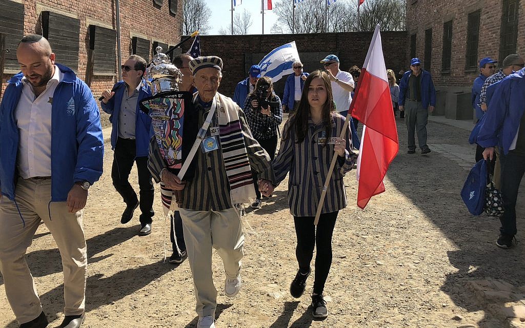 Edward Mosberg, holding a Torah scroll, takes part in the March of the Living in 2017 at the former Nazi death camp Auschwitz in Poland. (Courtesy of From the Depths via JTA) Edward Mosberg, holding a Torah scroll, takes part in the March of the Living in 2017 at the former Nazi death camp Auschwitz in Poland. (Courtesy of From the Depths via JTA)