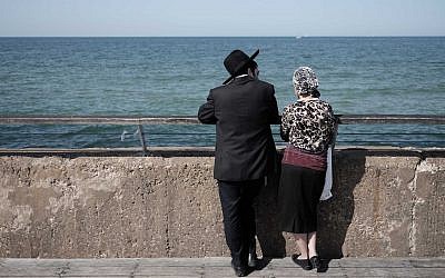 Illustrative: an ultra-Orthodox Jewish couple enjoys a sunny afternoon at the Tel Aviv port, February 5, 2016. (Tomer Neuberg/Flash90)