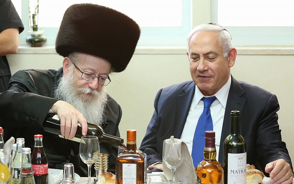 Prime Minister Benjamin Netanyahu is hosted by Minister of Health Yaakov Litzman of the United Torah Judaism party (left), at a meal to celebrate the birth of Litzman's grandson, June 18, 2017. (Shlomi Cohen/FLASH90) Prime Minister Benjamin Netanyahu is hosted by Minister of Health Yaakov Litzman of the United Torah Judaism party (left), at a meal to celebrate the birth of Litzman's grandson, June 18, 2017. (Shlomi Cohen/FLASH90)
