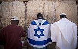 A man wearing an Israeli flag prays at the Western Wall in the Old City of Jerusalem, September 17, 2017.(Yonatan Sindel/Flash90)