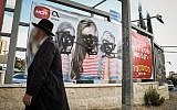 An ultra-Orthodox Jewish man walks past a vandalized billboard in Jerusalem where women's faces have been blotted out, November 2, 2017. (Noam Revkin Fenton/Flash90)