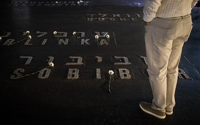 Relatives and friends of Holocaust survivors place flowers on names of concentration camps seen on the floor of the Hall of Remembrance at Yad Vashem on Holocaust Remembrance Day April 12, 2018. (Hadas Parush/Flash90) Relatives and friends of Holocaust survivors place flowers on names of concentration camps seen on the floor of the Hall of Remembrance at Yad Vashem on Holocaust Remembrance Day April 12, 2018. (Hadas Parush/Flash90)