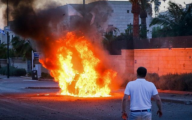 A car bursts into flames after it was hit by a rocket fired from the Gaza Strip in the southern Israeli city of Ashdod on May 5, 2019. (Flash90) A car bursts into flames after it was hit by a rocket fired from the Gaza Strip in the southern Israeli city of Ashdod on May 5, 2019. (Flash90)