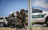 Illustrative: Israeli security forces take cover on the side of a highway near the Gaza border as the incoming rocket siren is heard on May 5, 2019. (Noam Rivkin Fenton/Flash90)