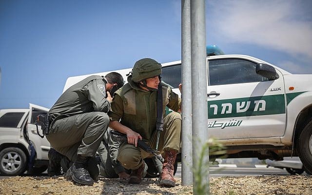 Illustrative: Israeli security forces take cover on the side of a highway near the Gaza border as the incoming rocket siren is heard on May 5, 2019. (Noam Rivkin Fenton/Flash90) Illustrative: Israeli security forces take cover on the side of a highway near the Gaza border as the incoming rocket siren is heard on May 5, 2019. (Noam Rivkin Fenton/Flash90)