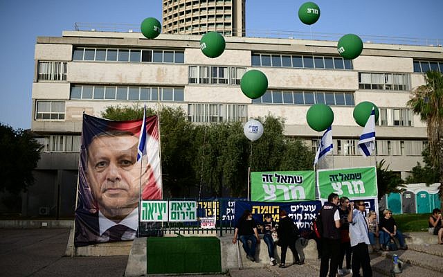 Israeli protesters holding up Meretz signs, and a photo of Turkey's Recep Tayyip Erdogan, take part in a demonstration outside the Tel Aviv Museum on May 25, 2019. (Tomer Neuberg/Flash90)