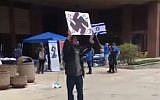Screen capture from video of a man holding up a swastika sign during an event marking Israel's Independence Day held at the University of Wisconsin-Milwaukee. (Twitter)