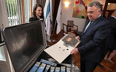 Israel's ambassador in Germany, Jeremy Issacharoff, right, holds documents prior to a handing over ceremony at the embassy of Israel in Berlin, Germany, Tuesday, May 21, 2019. German authorities are handing over to Israel some 5,000 documents kept by a confidant of Franz Kafka, a trove whose plight could have been plucked from one of the author's surreal stories. (AP Photo/Michael Sohn)