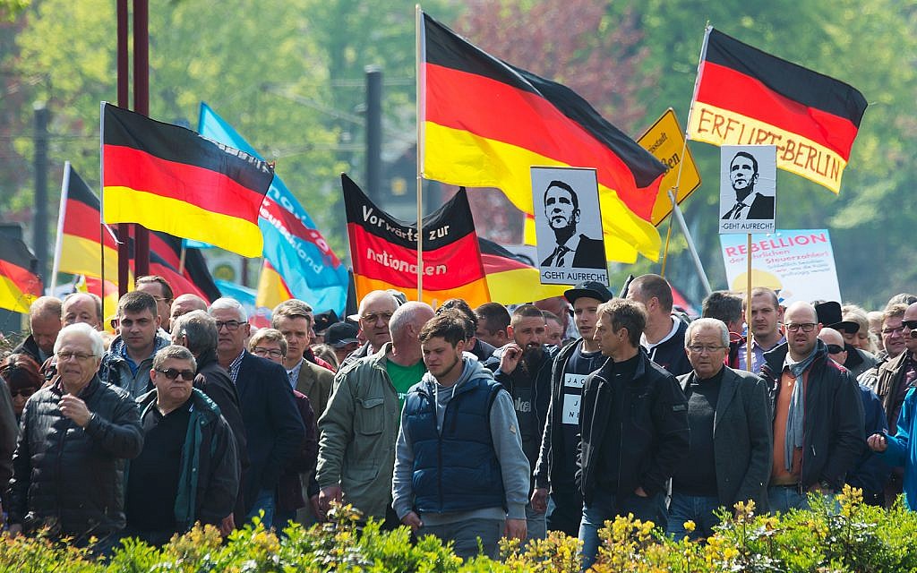 People hold flags during a demonstration by Germany's nationalist party AfD (Alternative for Germany) on May Day in Erfurt, central Germany, May 1, 2017. (AP/Jens Meyer) People hold flags during a demonstration by Germany's nationalist party AfD (Alternative for Germany) on May Day in Erfurt, central Germany, May 1, 2017. (AP/Jens Meyer)