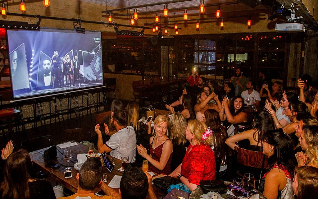 People watch the final of the 2019 Eurovision Song Contest at a pub in Tel Aviv, May 18, 2019. (Flash90)