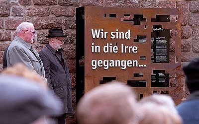 People stand around an installation during the official inauguration of a memorial in remembrance of the Institute for the Study and Elimination of Jewish Influence on German Church Life during the Third Reich in Eisenach, Germany, May 6, 2019. The words on the memorial read: 'We have gone astray'. (AP Photo/Jens Meyer)
