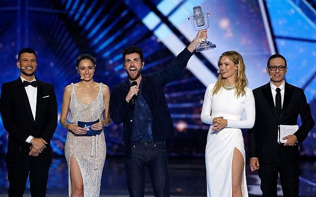 Duncan Laurence of the Netherlands, center, celebrates after winning the 2019 Eurovision Song Contest grand final with the song "Arcade" in Tel Aviv, May 18, 2019. He is flanked (from left) by the four Israeli hosts: Assi Azar, Lucy Ayoub, Bar Refaeli and Erez Tal (AP Photo/Sebastian Scheiner)