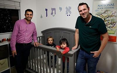 Elad Dvash-Banks, left, and his partner, Andrew, pose for photos with their twin sons, Ethan, center right, and Aiden in their apartment in Los Angeles, January 23, 2018 (AP Photo/Jae C. Hong, File)