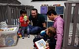 Elad Dvash-Banks, right, and his partner, Andrew, play with their twin sons, Ethan, left, and Aiden in their Los Angeles apartment, January 23, 2018. (AP Photo/Jae C. Hong)