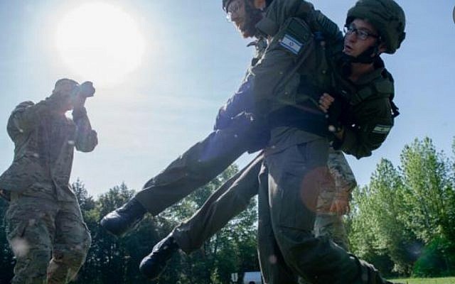 Lt. Netanel Ben-Ami carries Sgt. Stav Basudo during a US military combat photography competition in Quantico, Virgina, in May 2019. (Israel Defense Forces) Lt. Netanel Ben-Ami carries Sgt. Stav Basudo during a US military combat photography competition in Quantico, Virgina, in May 2019. (Israel Defense Forces)