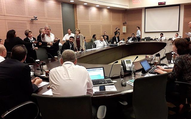 Ushers, at left, escort MK Mickey Levy (Blue and White) out of a Knesset committee debate on a bill to remove limits on the number of cabinet ministers that can be appointed by a government, May 21, 2019. (Knesset Spokesperson's Office) Ushers, at left, escort MK Mickey Levy (Blue and White) out of a Knesset committee debate on a bill to remove limits on the number of cabinet ministers that can be appointed by a government, May 21, 2019. (Knesset Spokesperson's Office)
