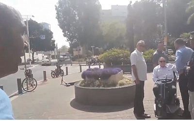 Activist Barak Cohen (L) films himself accosting Sheldon Adelson (seated) in Tel Aviv (Screencapture/Twitter)