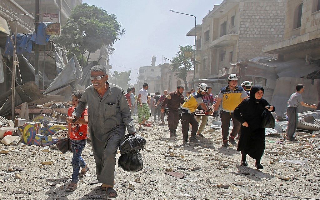 Members of the Syrian Civil Defense (known as the White Helmets) carry a wounded man on a stretcher following an air strike on the town of Maaret al-Numan in Idlib province on June 3, 2019. (Abdulaziz Ketaz/AFP)