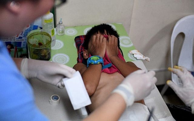 This photo take on May 10, 2019, shows a boy writhing in pain during a mass circumcision at a village health center in Manila, Philippines. (Photo by Noel CELIS / AFP) This photo take on May 10, 2019, shows a boy writhing in pain during a mass circumcision at a village health center in Manila, Philippines. (Photo by Noel CELIS / AFP)