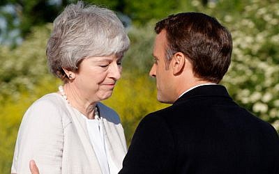 French President Emmanuel Macron greets British Prime Minister Theresa May during a ceremony to lay the first stone of the British Normandy Memorial in Ver-sur-Mer, Normandy, northwestern France, on June 6, 2019, as part of D-Day commemorations (PHILIPPE WOJAZER / POOL / AFP)