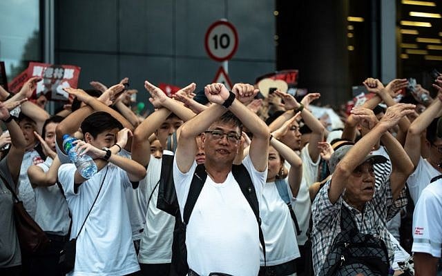Protesters gesture as they chant 'no extradition' as they rally against a controversial extradition law proposal in Hong Kong on June 9, 2019 (Philip Fong/AFP)