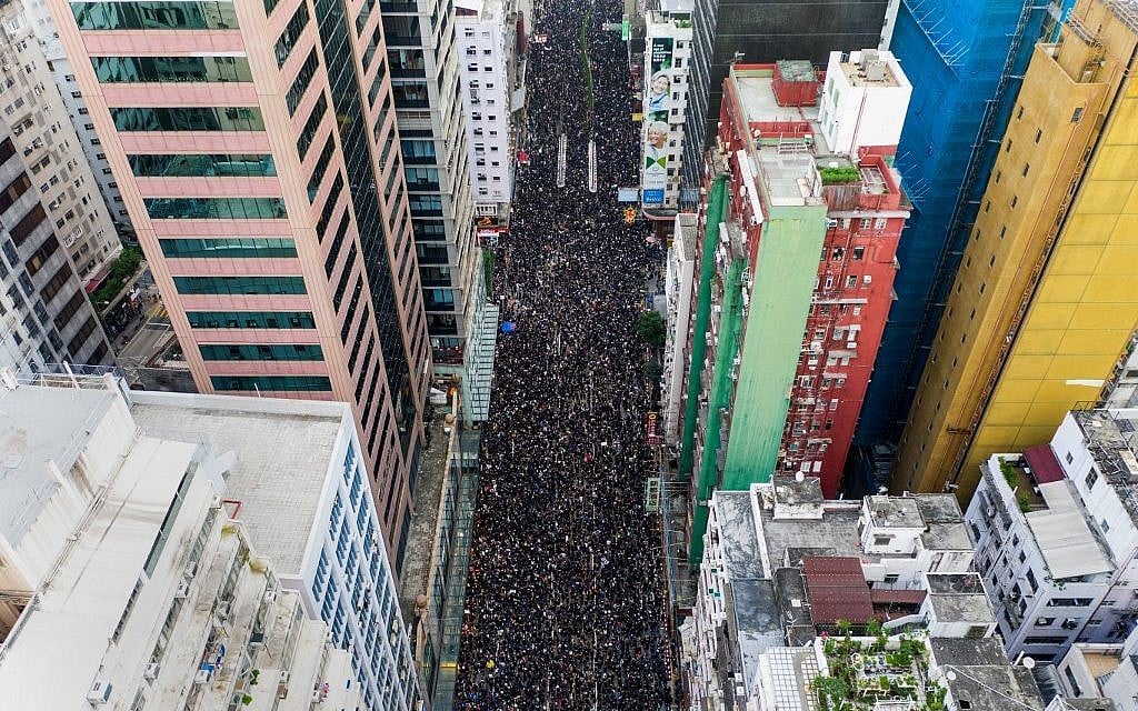 This overhead view shows thousands of protesters marching through the street as they take part in a new rally against a controversial extradition law proposal in Hong Kong on June 16, 2019. (STR / AFP)