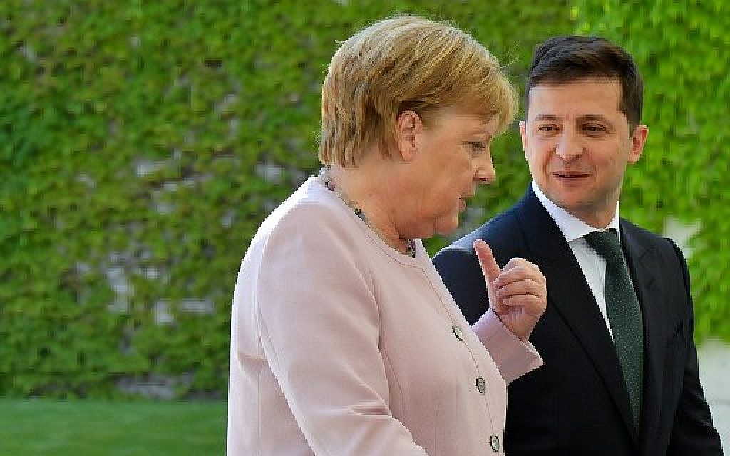 German Chancellor Angela Merkel and new Ukrainian President Volodymyr Zelensky walk to the chancellery after they inspect a military honor guard on June 18, 2019 in Berlin. (Tobias SCHWARZ / AFP)