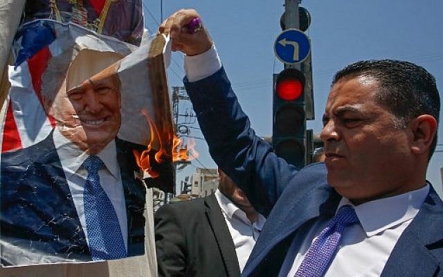 A Palestinian man burns a photo of US President Donald Trump during protests against a US-led meeting this week in Bahrain on the Palestinian-Israeli conflict, in the village of Halhul, near the West Bank city of Hebron on June 24, 2019. (Hazem Bader/AFP) A Palestinian man burns a photo of US President Donald Trump during protests against a US-led meeting this week in Bahrain on the Palestinian-Israeli conflict, in the village of Halhul, near the West Bank city of Hebron on June 24, 2019. (Hazem Bader/AFP)