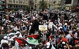 Palestinian demonstrators carry banners and national flags during a protest against the US-sponsored Middle East economic conference that opened in Bahrain, in the West Bank city of Nablus on June 25, 2019. (Jaafar Ashtiyeh/AFP)