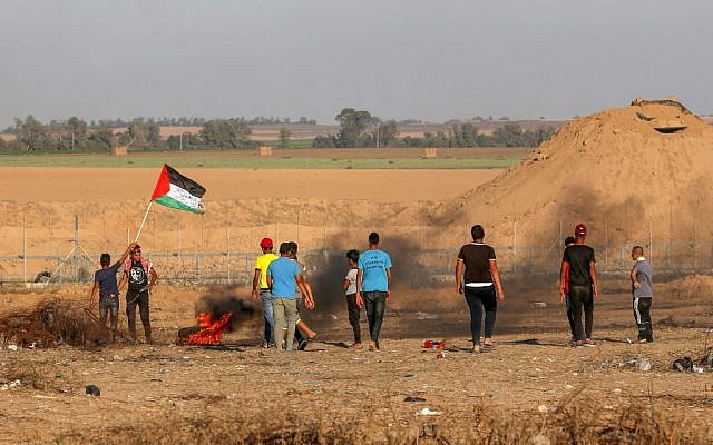A Palestinian protester waves the national flag during a demonstration along the fence east of Khan Yunis in the southern Gaza Strip on June 26, 2019. (Said Khatib/AFP) A Palestinian protester waves the national flag during a demonstration along the fence east of Khan Yunis in the southern Gaza Strip on June 26, 2019. (Said Khatib/AFP)