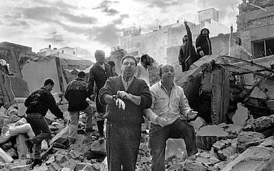 Firemen and civilians walk over the rubble left after a bomb exploded at the AMIA Jewish center in Buenos Aires, Argentina, July 18, 1994. (Ali Burafi/AFP/Getty Images/via JTA)