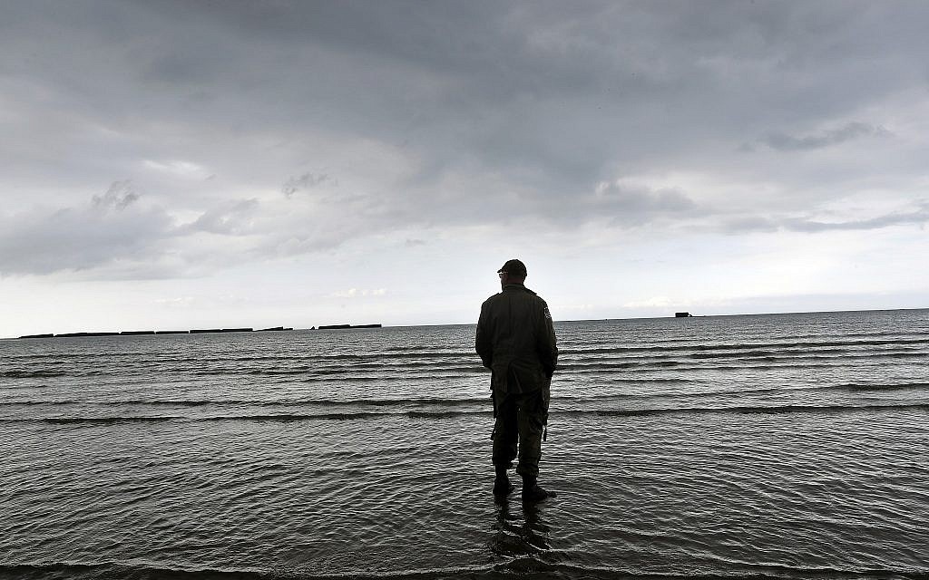 An enthusiast stands on the beach of Arromanches, June 4, 2019 in Normandy. Extensive commemorations are being held in the UK and France this week to honor the nearly 160,000 troops from Britain, the United States, Canada and other nations who landed in Normandy on June 6, 1944 in history's biggest amphibious invasion. (AP Photo/Thibault Camus)