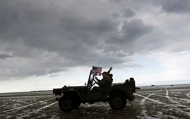 Enthusiasts ride a jeep on the beach of Arromanches, June 4, 2019 in Normandy. Extensive commemorations are being held in the UK and France this week to honor the nearly 160,000 troops from Britain, the United States, Canada and other nations who landed in Normandy on June 6, 1944 in history's biggest amphibious invasion. (AP Photo/Thibault Camus)