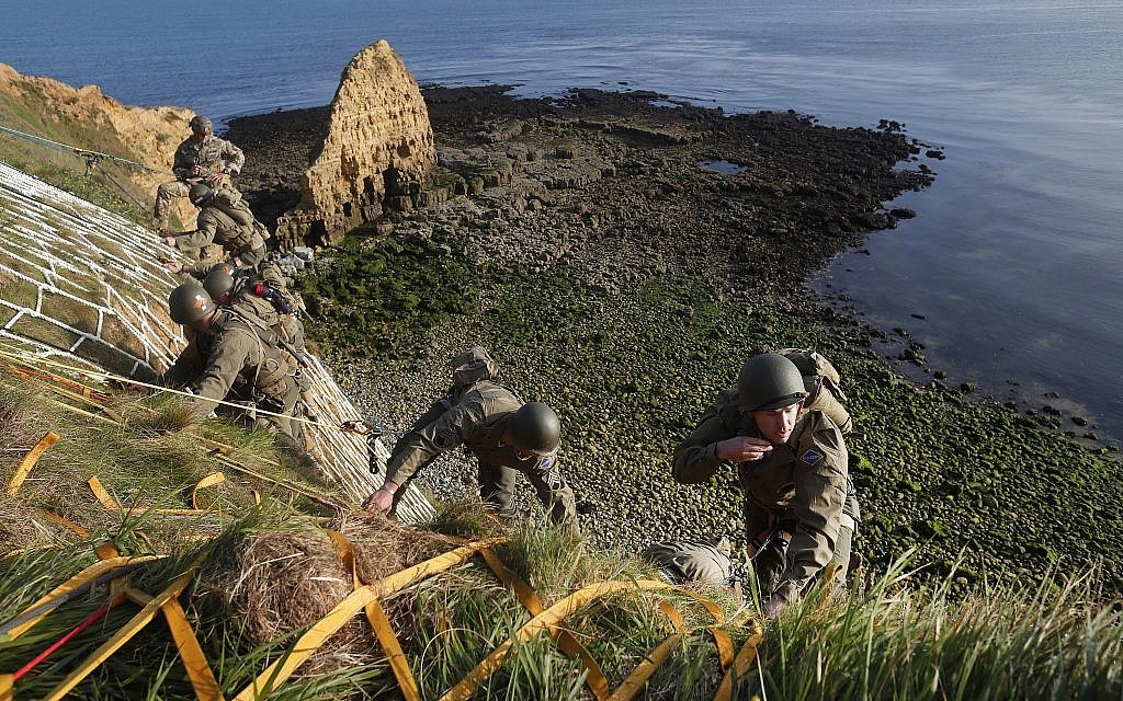 Soldiers from the US 75th Ranger Regiment, in period dress, climb the cliff of Pointe-du-Hoc in Cricqueville-en-Bessin, Normandy, France, June 5, 2019. During the American assault of Omaha and Utah beaches on June 6, 1944, US Army Rangers scaled the 100-foot cliffs to seize German artillery pieces that could have fired on the American landing troops. (AP Photo/Thibault Camus)