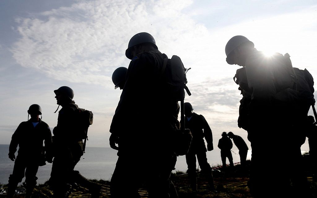 Soldiers from the US 75th Ranger Regiment, in period dress, stand on the overlook after climbing the cliffs of Pointe-du-Hoc in Cricqueville-en-Bessin, Normandy, France, June 5, 2019. During the American assault of Omaha and Utah beaches on June 6, 1944, US Army Rangers scaled the 100-foot cliffs to seize German artillery pieces that could have fired on the American landing troops. (AP Photo/Thibault Camus)