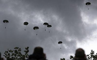 Spectators watch parachutists jumping just as soldiers did 75 years earlier for D-Day, on June 5, 2019 in Carentan, Normandy. (AP Photo/Rafael Yaghobzadeh)
