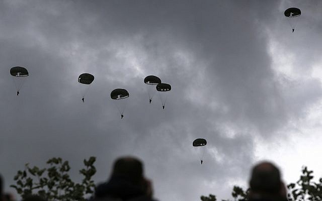 Spectators watch parachutists jumping just as soldiers did 75 years earlier for D-Day, on June 5, 2019 in Carentan, Normandy. (AP Photo/Rafael Yaghobzadeh)