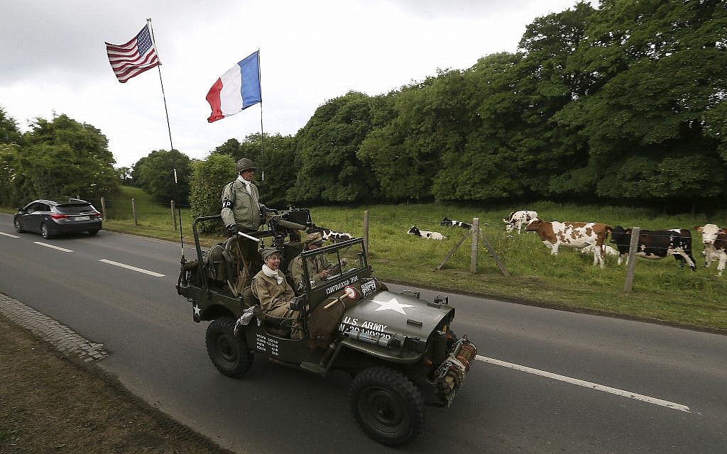 Cows watch WWII enthusiasts driving a jeep in Colleville-sur-Mer, Normandy, June 5, 2019. Extensive commemorations are being held in the UK and France to honor the nearly 160,000 troops from Britain, the United States, Canada and other nations who landed in Normandy on June 6, 1944 in history's biggest amphibious invasion. (AP Photo/David Vincent)