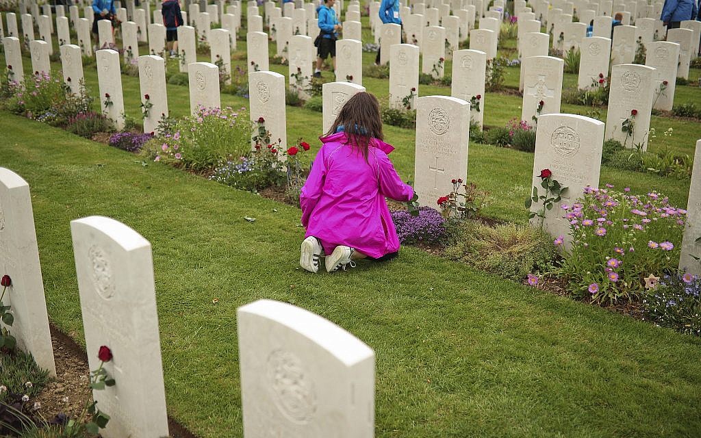 A young girl places a flower on the grave of a British soldier who fell in WWII, at the Bayeux War Cemetery in Bayeux, Normandy, France, June 5, 2019. Extensive commemorations are being held in the UK and France to honor the nearly 160,000 troops from Britain, the United States, Canada and other nations who landed in Normandy on June 6, 1944 in history's biggest amphibious invasion. (AP Photo/Francisco Seco)