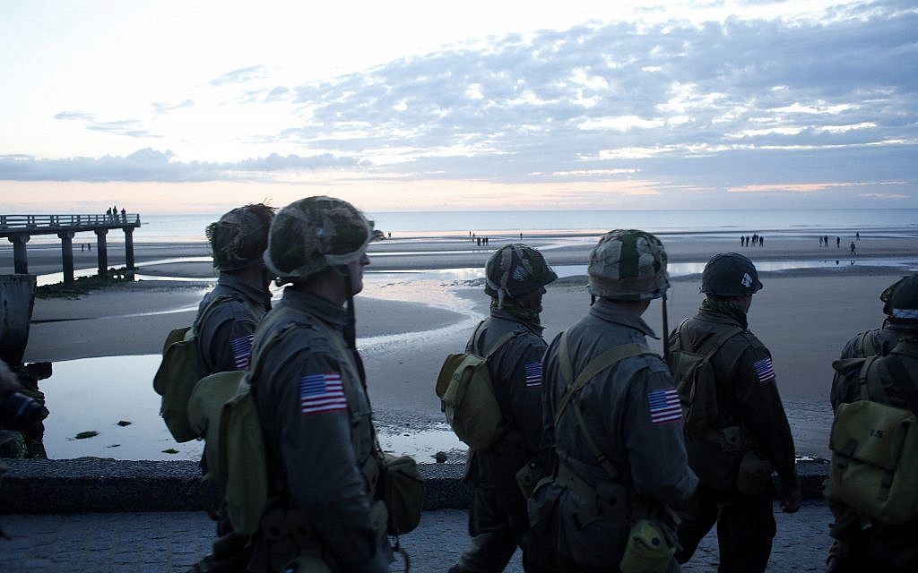 World War II reenactors walk down to Omaha Beach, in Normandy, France, at dawn on June 6, 2019 during commemorations of the 75th anniversary of D-Day. (AP Photo/Thibault Camus)