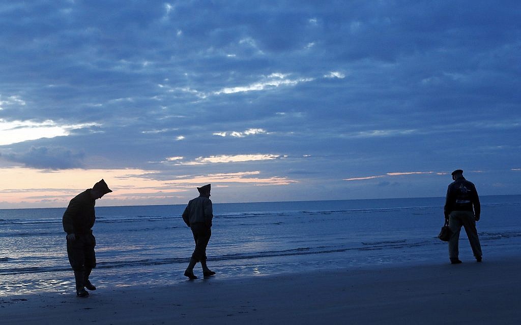 World War II reenactors walk along Omaha Beach, in Normandy, France, at dawn on June 6, 2019 during commemorations of the 75th anniversary of D-Day. (AP Photo/Thibault Camus)