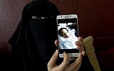 In this May 27, 2019 photo, Muna Awad, mother of 5-year-old Aisha al-Loulu, shows a photo of her daughter while in a Jerusalem hospital, at the family home in the Bureij refugee camp in the central Gaza Strip. (AP Photo/Hatem Moussa)
