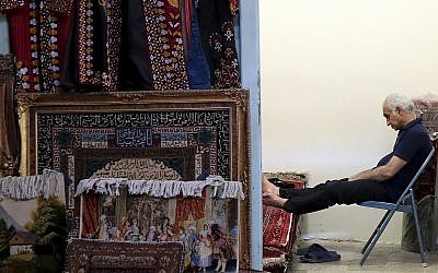 A carpet seller sits at his shop in the old main bazaar in Tehran, Iran, on June 23, 2019. (AP Photo/Ebrahim Noroozi)