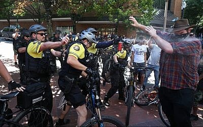 After a confrontation between authorities and protesters, police use pepper spray as multiple groups, including Rose City Antifa, the Proud Boys and others protest in downtown Portland, Oregon on Saturday, June 29, 2019. (Dave Killen/The Oregonian/AP)