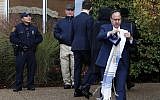 Illustrative: A worshiper walks past a Pittsburgh Police officer, and a private security guard outside the main entrance of the Beth Shalom synagogue after attending a Shabbat morning service on Nov. 3, 2018 in Pittsburgh. (AP Photo/Gene J. Puskar)