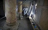 In this Thursday, Dec. 6, 2018 photo, a restoration expert works on a granite column inside the Church of the Nativity, built atop the site where Christians believe Jesus Christ was born, in the West Bank City of Bethlehem. (AP/Majdi Mohammed)